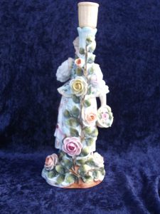 This is the back of the figurine, showing more fabricated rose petals and vines.